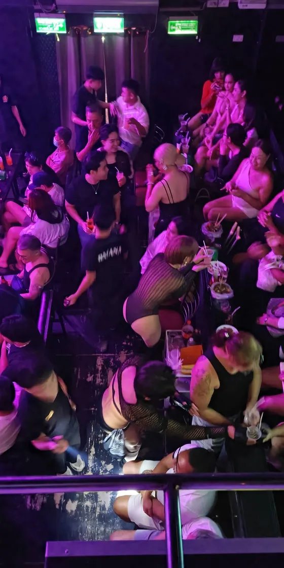 Packed dance floor with the crowd dancing under club lighting