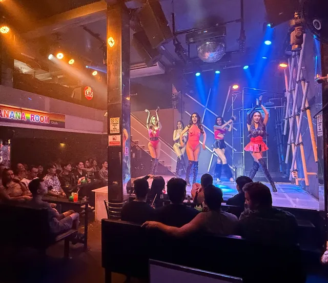 Wide view of the showroom with a seated audience facing the lit stage